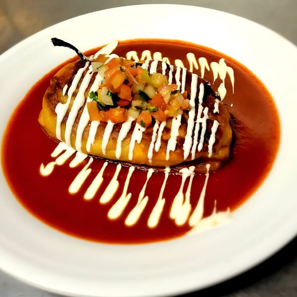 A Fuego Mexican Kitchen chile relleno with pico de gallo, sour cream, and red sauce.